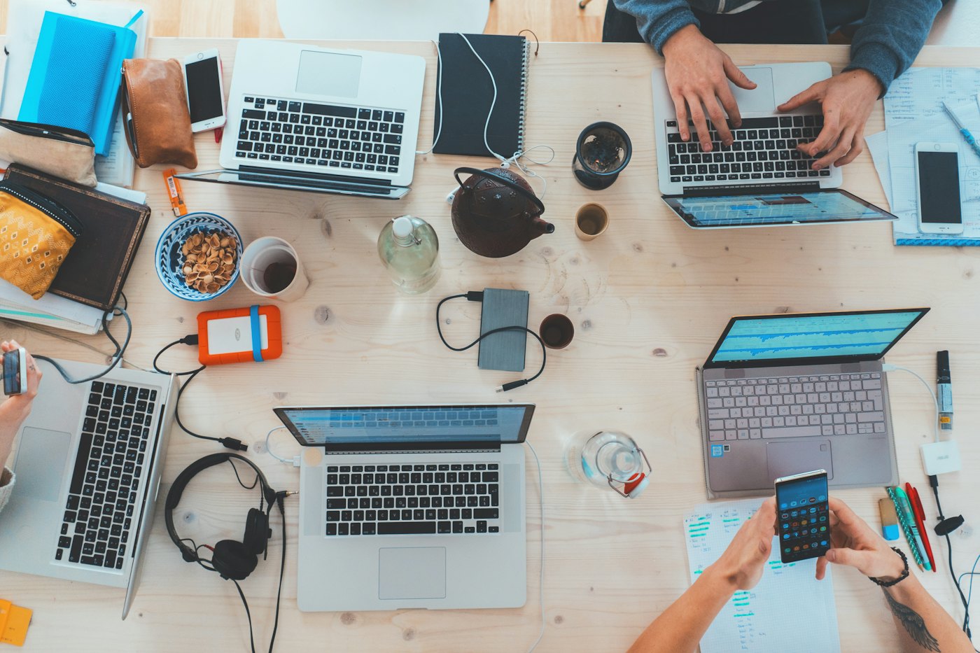 Overhead view of a team's shared desk with laptops