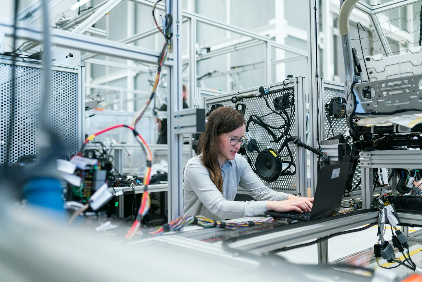Engineer working at a laptop beside manufacturing equipment